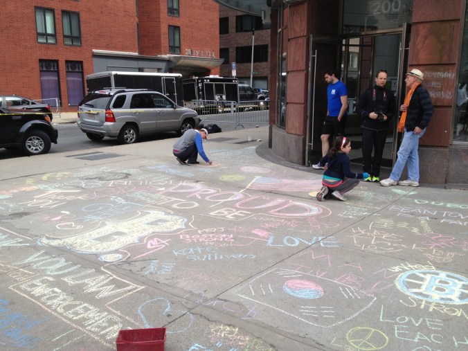 Writing sentiments on chalk on sidewalk